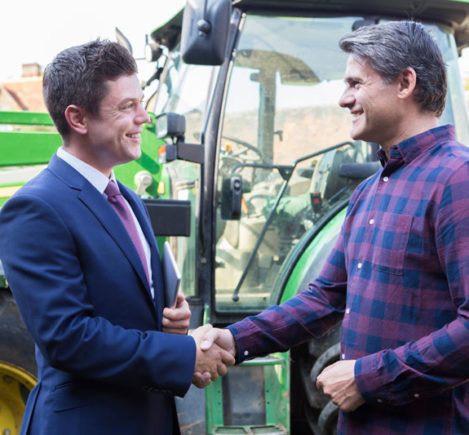 business man shakes hand with farmer