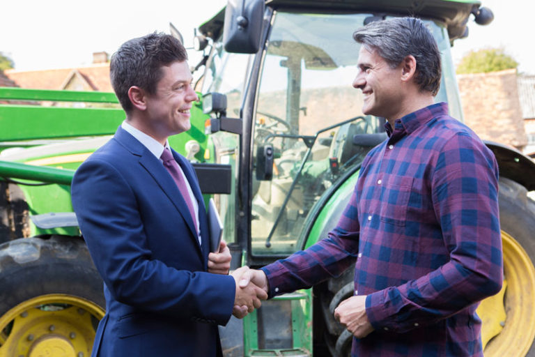business man shakes hand with farmer