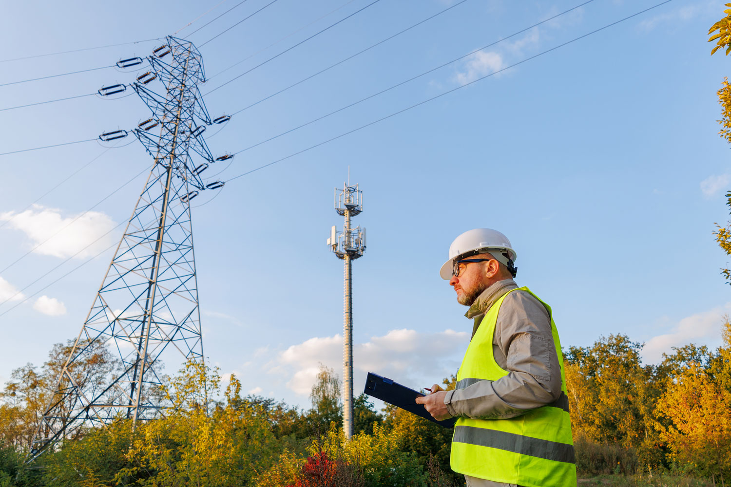 Professional stands in foreground with power lines and telecom tower in the background
