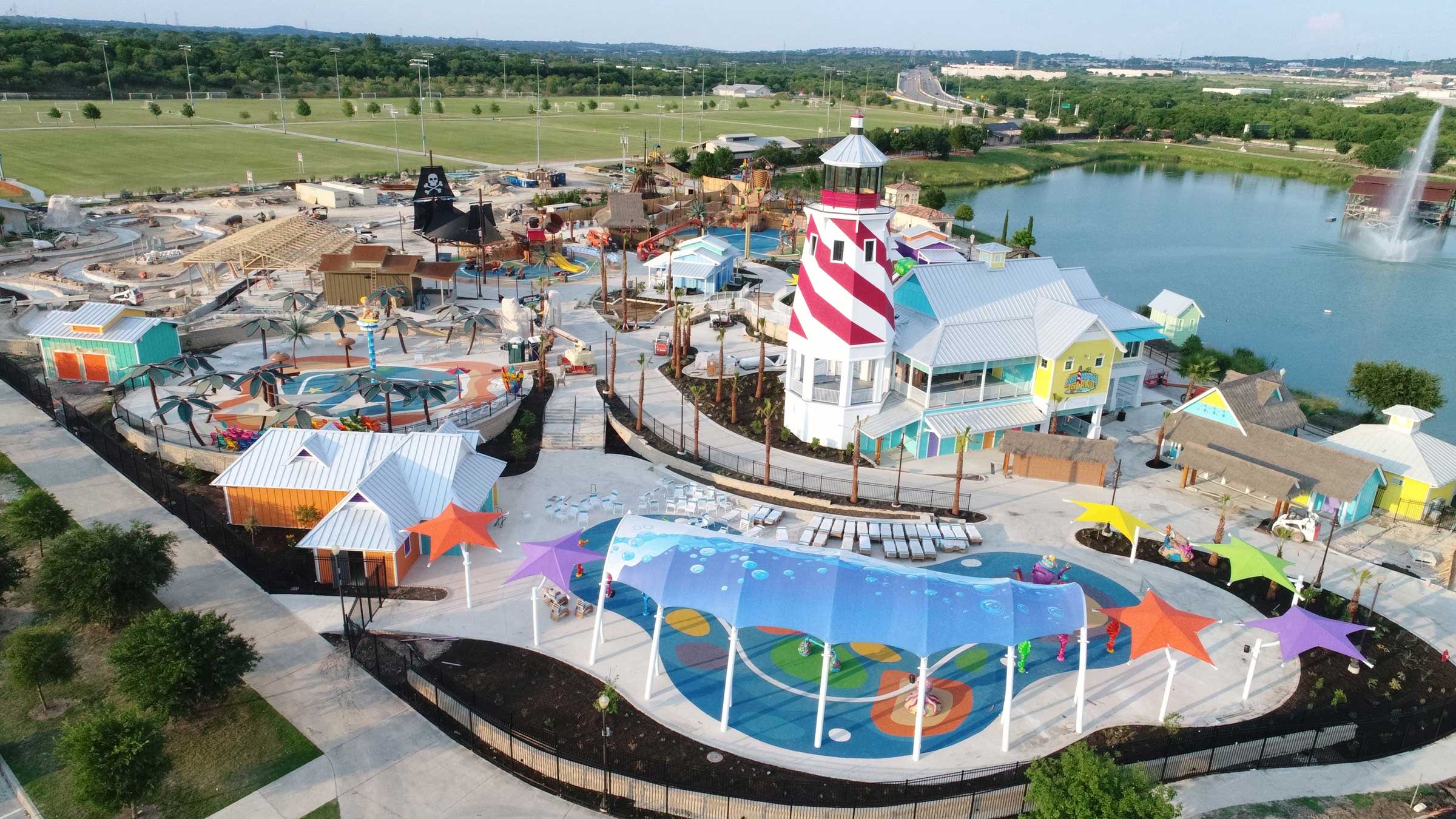 ADA accessible amusement park featuring rides, colorful attractions, and a lighthouse at the center of the park.