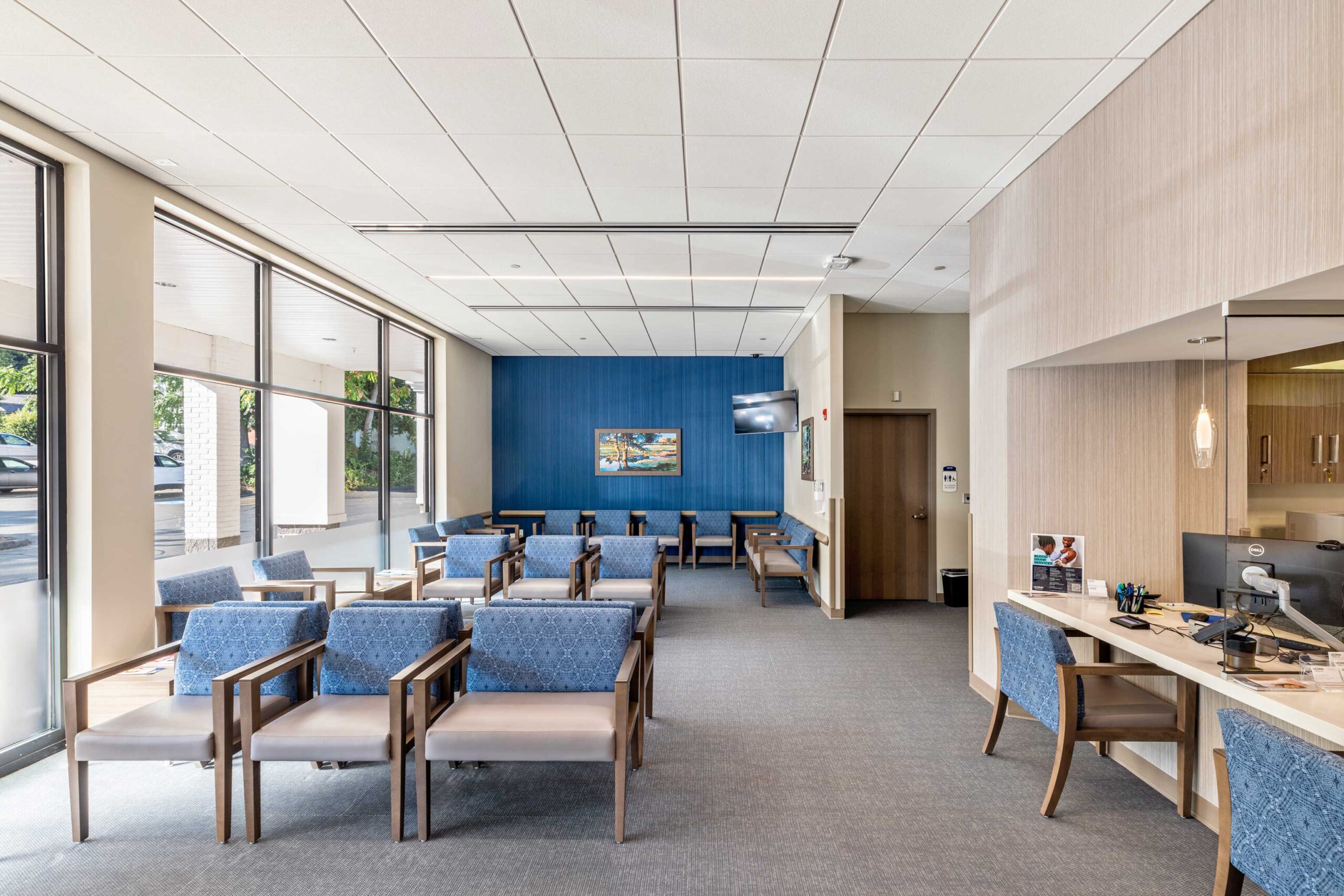 A waiting room filled with seating alongside a glass window at UConn Health Outpatient Facility.