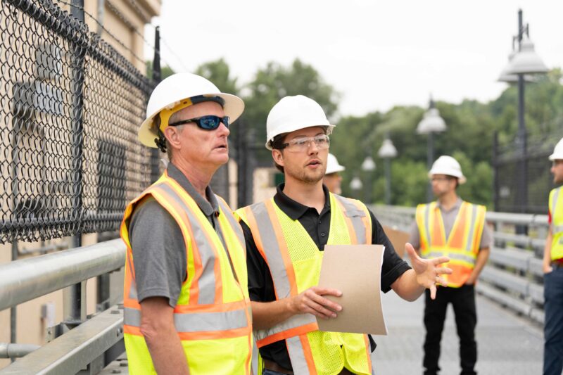 Engineers discussing dam gate installation improvements.