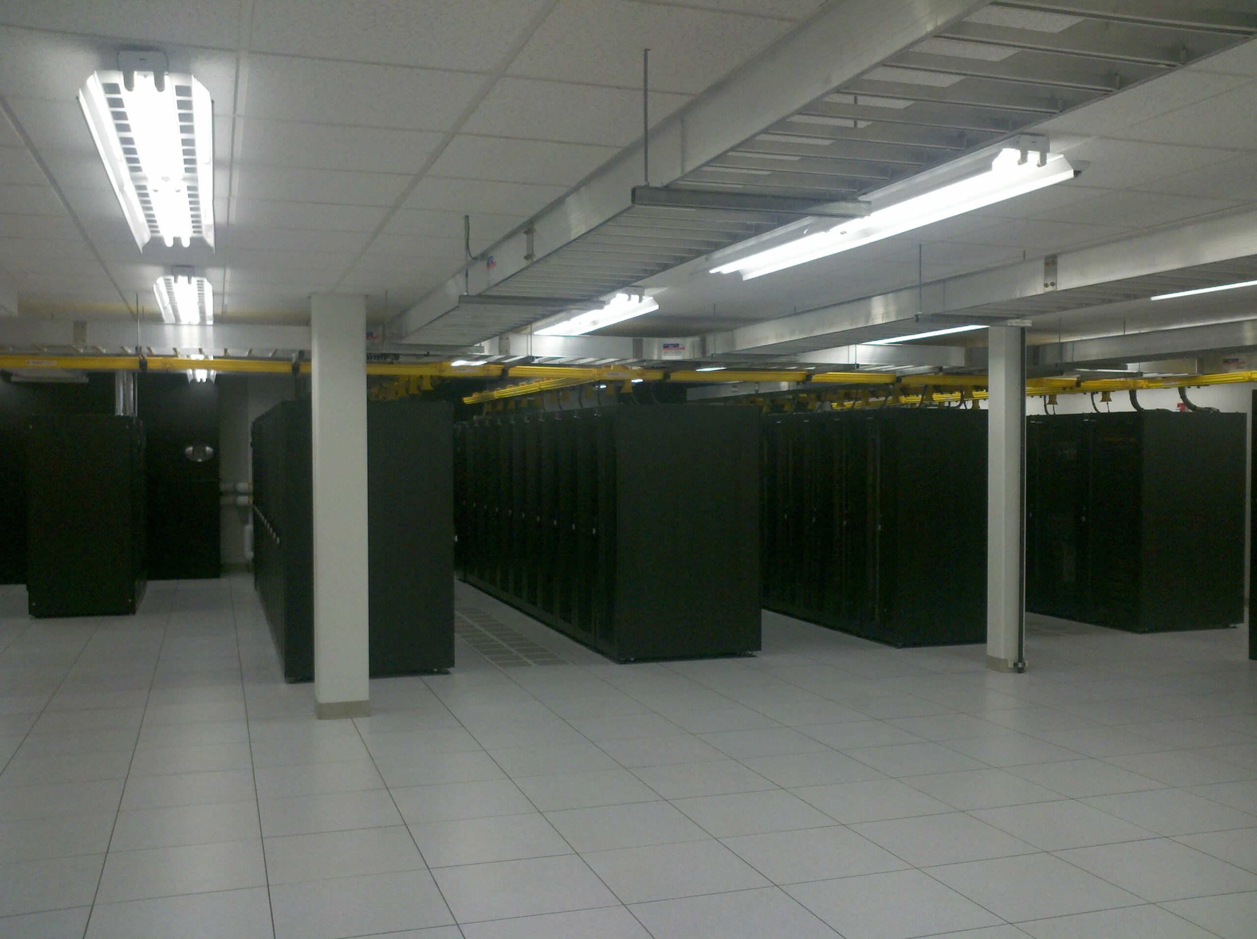 Server room featuring raised floors, hot aisle/cold aisle layouts, and storage racks.