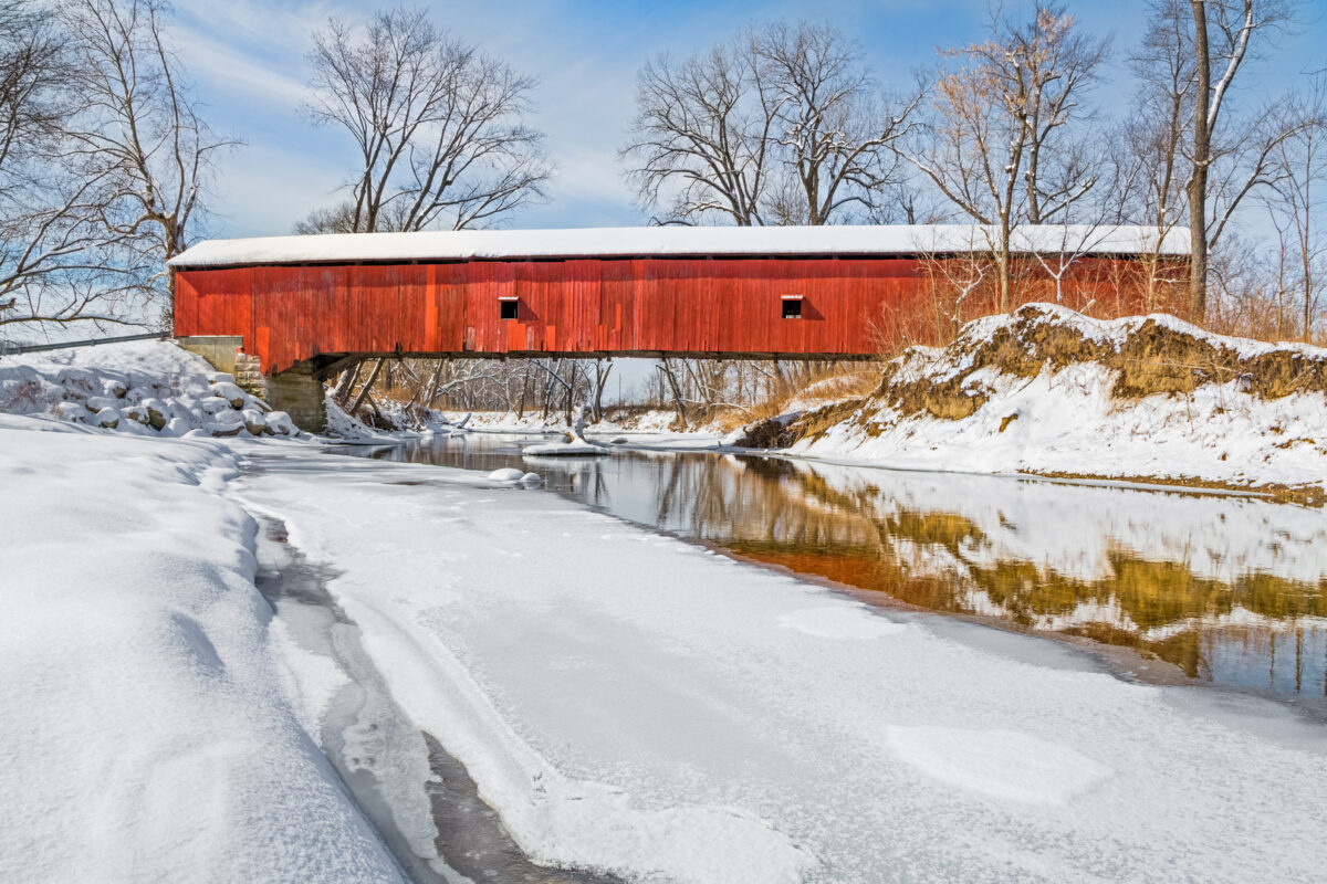 In the midst of a snowy winter landscape, the historic Oakalla Covered Bridge crosses Big Walnut Creek in rural Putnam County, Indiana.
