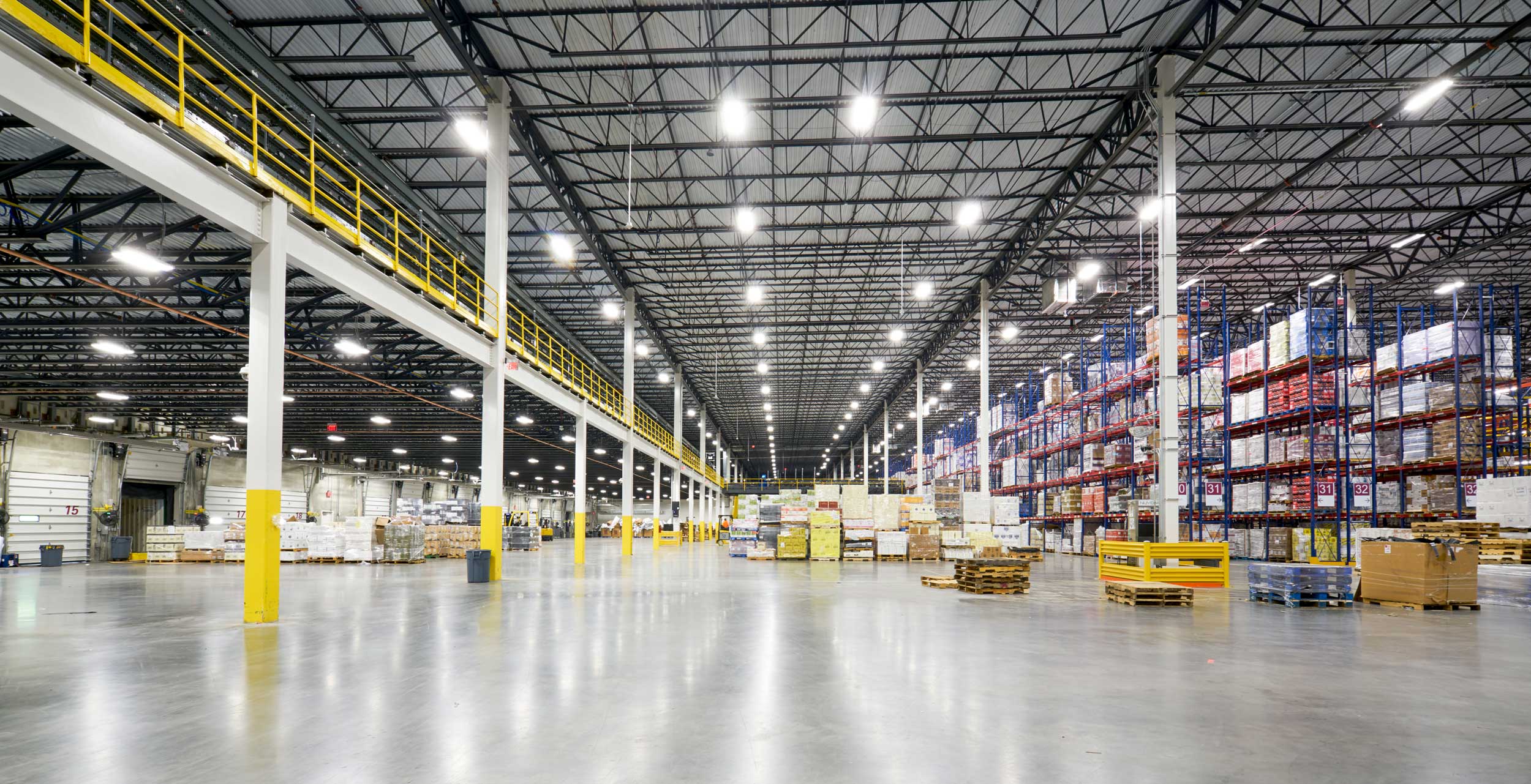Open warehouse with pallet jacks and products stored in place.