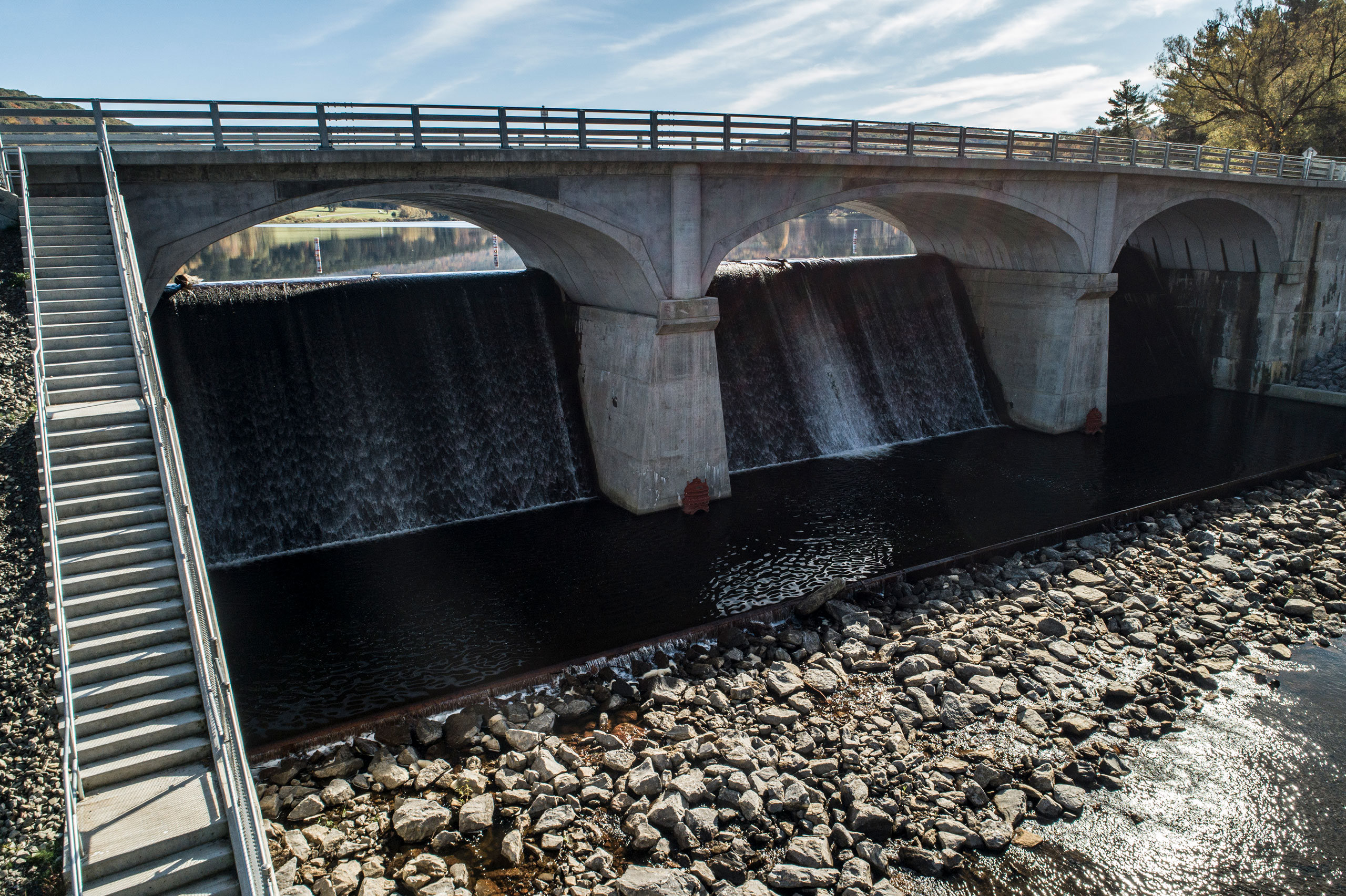 Dam under bridge with flowing water
