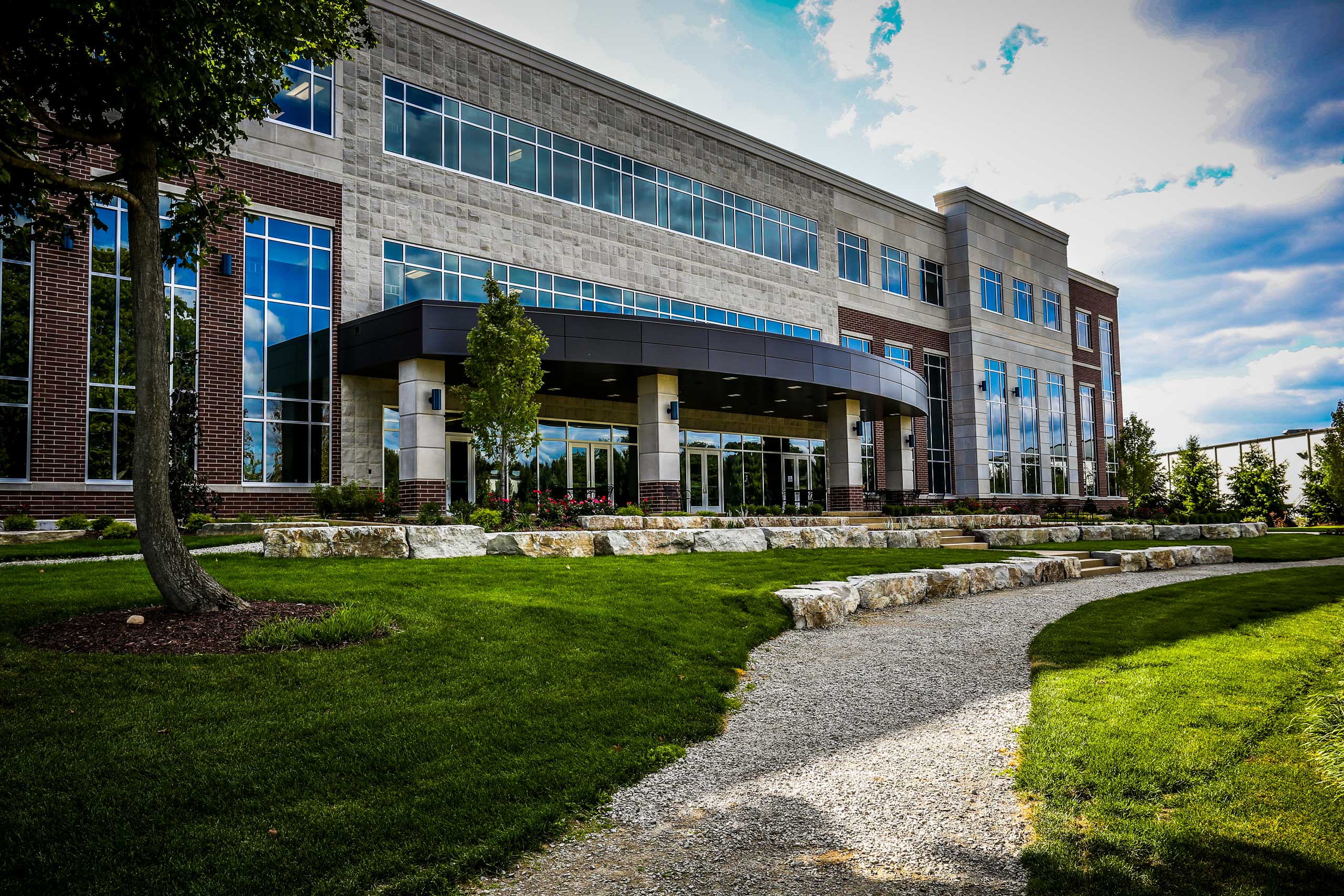 Rear exterior facade of the Technology and Information Center for Dart Container Corporation is a multi-story glass and stone building