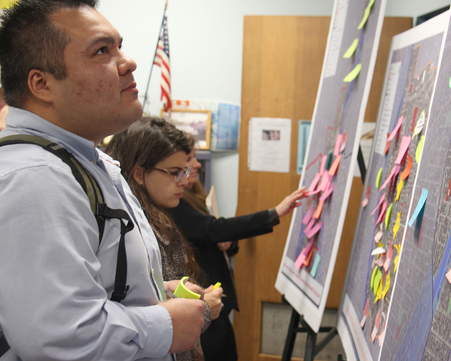 Individuals analyze post it board at public funding meeting