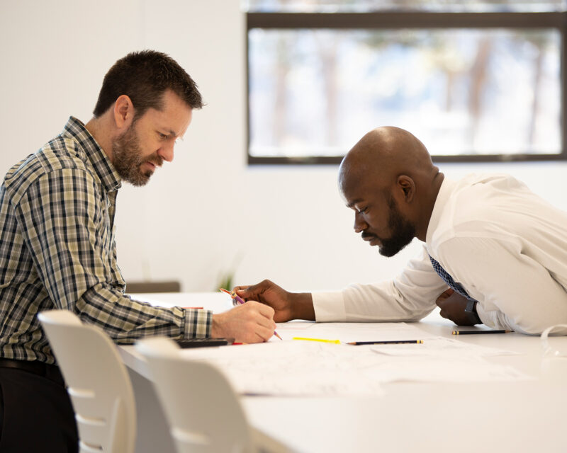 Two professionals look over documents